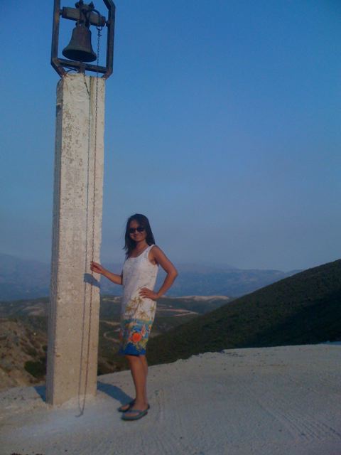 Anne Ku posing next to Cretan church bell in Paleochora, Crete